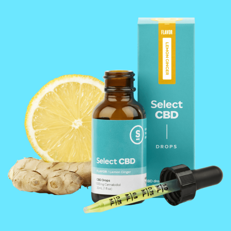 A bottle of SelectCBD Drops is displayed with packaging, dropper, a slice of lemon, and ginger.