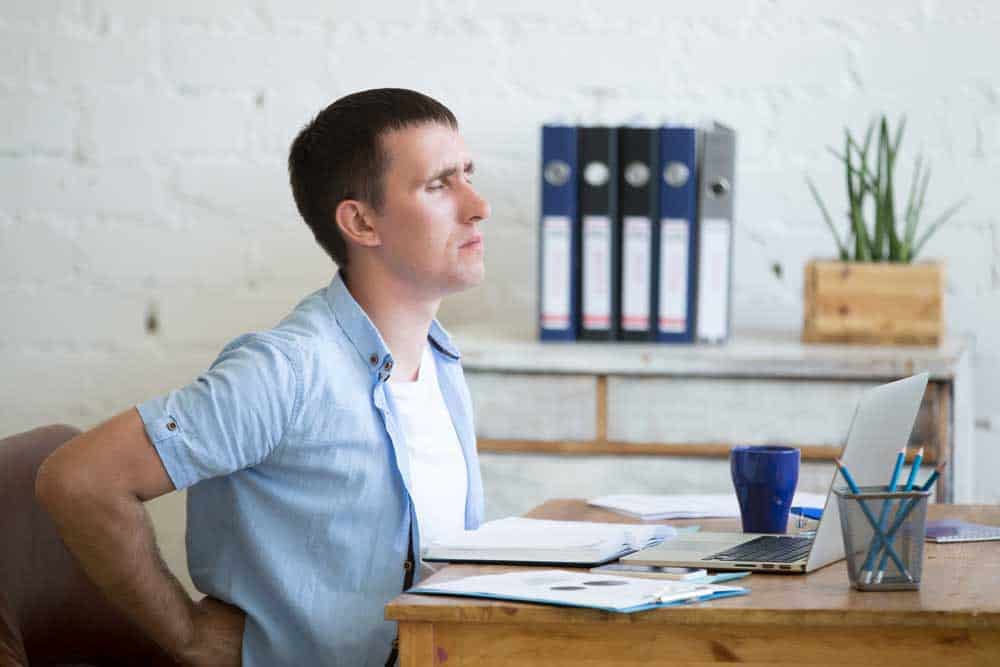 person sitting on chair having back-pain